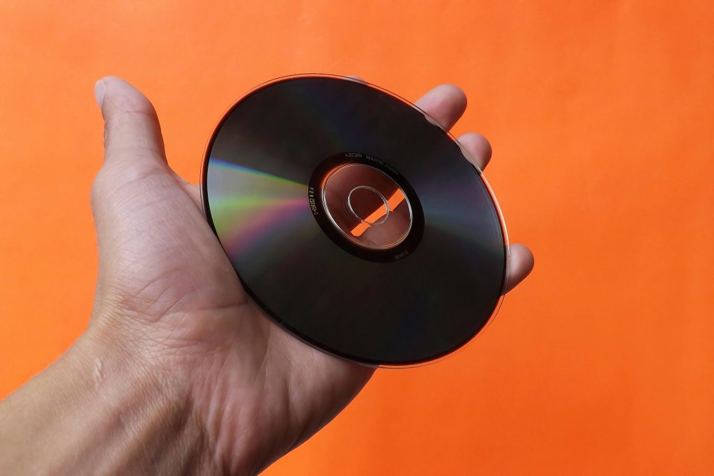 A person holds a CD in their hand