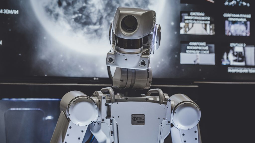A robot stands against a dark background. Such robots are merging more and more with AI – setting the stage for widespread disruption and human displacement from the workforce.