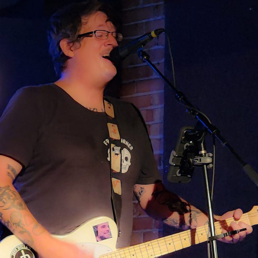 Jeff Dillon playing the guitar in Salt Lake City at Mark of the Beastro.